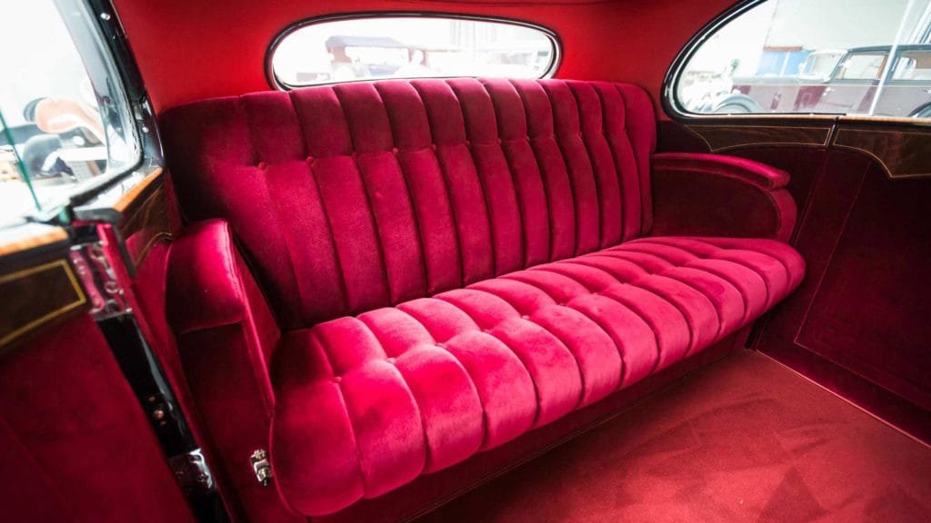 View of the plush interiors of Hispano Suiza upholstered in rich maroon velvet; Photo Credit: https://www.artcurial.com/en/lot-1937-hispano-suiza-j12-gurney-nutting-3279-28