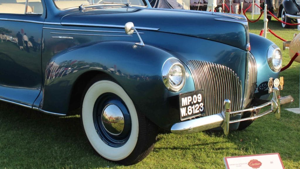 Closeup view of the bonnet, ‘teardrop’ headlights, silver speed lines and split ‘waterfall’ radiator grille of Lincoln Zephyr 1941, Photo Credit: Karl Bhote